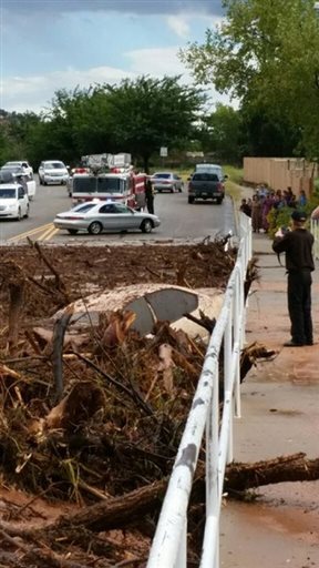 A vehicle rests in debris after a flash flood Monday, Sept. 14, 2015, in Hildale, Utah. Authorities say multiple people are dead and others missing after a flash flood ripped through the town on the Utah-Arizona border Monday night. (Mark Lamont via AP) 