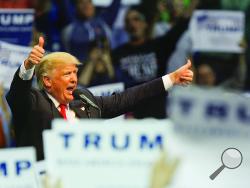  In this file photo, Donald Trump can be seen through the waving signs of his supports as he address the capacity crowd at Mohegan Sun Arena in Wilkes-Barre Township Monday evening. (Press Enterprise/Jimmy May)