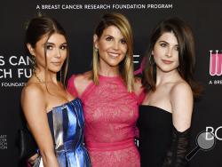 FILE - In this Feb. 28, 2019 file photo, actress Lori Loughlin, center, poses with daughters Olivia Jade Giannulli, left, and Isabella Rose Giannulli at the 2019 "An Unforgettable Evening" in Beverly Hills, Calif. Loughlin and her husband Mossimo Giannulli were charged along with nearly 50 other people Tuesday in a scheme in which wealthy parents bribed college coaches and other insiders to get their children into some of the most elite schools in the country, federal prosecutors said. (Photo by Chris Pizze