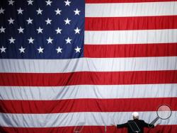 FILE - In this Sunday, Nov. 6, 2016 file photo, Republican presidential candidate Donald Trump turns to face the U.S. flag at a campaign rally in Sterling Heights, Mich. (AP Photo/Paul Sancya)