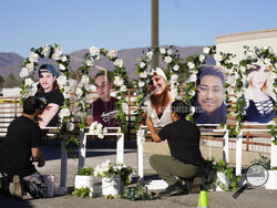 Noah Reich, left, and David Maldonado, the Los Angeles co-founders of Classroom of Compassion, put up a memorial with photographs of the five victims of a weekend mass shooting at a nearby gay nightclub on Tuesday, Nov. 22, 2022, in Colorado Springs, Colo. Anderson Lee Aldrich opened fire at Club Q, in which five people were killed and others suffered gunshot wounds before patrons tackled and beat the suspect into submission. (AP Photo/David Zalubowski)