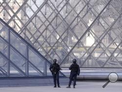 Police officers patrol at the pyramid outside the Louvre museum in Paris,Friday, Feb. 3, 2017. Paris police say a soldier has opened fire outside the Louvre Museum after he was attacked by someone, and the area is being evacuated. (AP Photo/Thibault Camus)