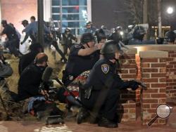 Police take cover after two officers were shot while standing guard in front of the Ferguson Police Station on Thursday, March 12, 2015. (AP Photo/St. Louis Post-Dispatch, Laurie Skrivan)