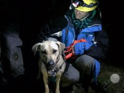 Dr. Amy Amsler, Oregon Humane Society volunteer during a rescue of Sandy a yellow Labrador who got spooked on a Christmas Day hike in the Columbia Gorge. Sandy snapped her leash and plunged 150 feet down a cliff before being rescued in the dark by climbers who rappelled to a narrow ledge where the animal was trapped. The Oregon Humane Society said the dog suffered only minor injuries. (AP Photo/ Emily Amsler via Oregon Humane Society)