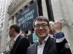 In a Thursday, June 18, 2015 file photo, Fitbit CEO James Park shows off one of his devices as he poses for photos outside the New York Stock Exchange, before his company's IPO. (AP Photo/Richard Drew, File)
