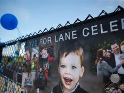In this Saturday, Sept. 3, 2016, photo, banners with a collage of photos of Lane Graves and his family hang on display with blue balloons and ribbons for a Love for Lane Celebration on what would have been his third birthday at Elkhorn South High School in Omaha, Neb. (Rebecca S. Gratz/Omaha World-Herald via AP) 