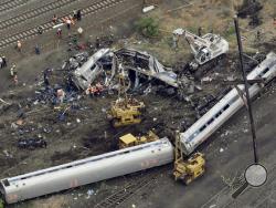 In this Wednesday, May 13, 2015 file photo, emergency personnel work at the scene of a Tuesday night derailment in Philadelphia of an Amtrak train headed to New York. The National Transportation Safety Board is scheduled to meet Tuesday, May 17, 2016, to detail the probable cause of last year's fatal derailment. (AP Photo/Patrick Semansky, File)