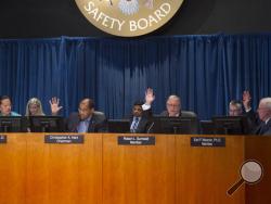 Members of the National Transportation Safety Board (NTSB) votes on a motion to adopt an explanation for the derailment of an Amtrak passenger train that derailed in Philadelphia last year, Tuesday, May 17, 2016, during their board meeting in Washington. Board members, from left are; T. Bella Dihn-Zarr, Ph.D. vice chair, Christopher Hart, chairman, Robert Sumwalt, member, and Earl Weener, Ph.D., member. (AP Photo/Cliff Owen)