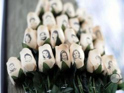 In this Jan. 14, 2013, file photo, white roses with the faces of victims of the Sandy Hook Elementary School shooting are attached to a telephone pole near the school in Newtown, Conn. (AP Photo/Jessica Hill, File)