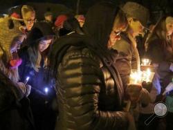 FILE - In this Jan. 29, 2016 file photo, people hold candles in memory of the three deceased Sheboygan Falls children at River Park in Sheboygan Falls, Wis. Natalie Renee Martin, 11, Carter Maki, 7, and Benjamin Martin, 10, died in a house fire Jan. 26. Natalie, who died saving the lives of even younger children, is among 21 people being honored with Carnegie medals for heroism. The Carnegie Hero Fund Commission, based in Pittsburgh, announced the winners Tuesday, Dec. 20. (Gary C. Klein/The Sheboygan Press