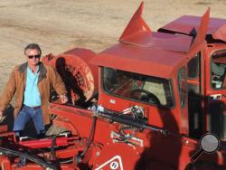 In this Dec. 27, 2016 photo, farmer Kevin Herman stands next to an almond sweeper at his ranch near Madera, Calif. Herman says that Donald Trump's campaign vow to deport millions of immigrants who are in the country illegally pushed him into buying more equipment, cutting the number of workers he'll need during the next harvest. (AP Photo/Scott Smith)