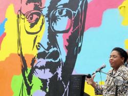 FILE - In this May 13, 2016 file photo, Jennifer Pinckney speaks beside an image of her late husband, the Rev. Clementa Pinckney, one of the victims of the shooting at Charleston's Emanuel AME Church, during the unveiling of the mural on a building a few blocks from the sanctuary. (AP Photo/Bruce Smith, File)