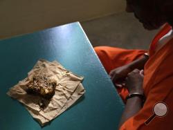 In this Oct. 26, 2016 photo, a nutraloaf, a meal typically given to inmates for misbehavior involving food or bodily waste, sits in front of inmate Kevin Dickens during an interview with The Associated Press at James T. Vaughn Correctional Center in Smyrna, Del. (AP Photo/Patrick Semansky)