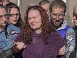 A distraught Rose Hunsicker, center, the biological mother of Grace Packer, is escorted to the church by members of her family and members of Bikers Against Child Abuse Monday, Jan. 16, 2017, on her way in to a memorial service for Packer, the local teen who who authorities say was killed and dismembered by her adoptive mother and her boyfriend, at the New Life Presbyterian Church in Glenside, Pa. (Ed Hille/The Philadelphia Inquirer via AP)