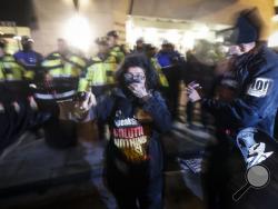 Protesters cover their faces after being pepper sprayed following a scuffle outside the National Press Club ahead of the presidential inauguration, Thursday, Jan. 19, 2017, in Washington. (AP Photo/John Minchillo)