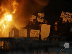 Protestors watch a bonefire on Sproul Plaza during a rally against the scheduled speaking appearance by Breitbart News editor Milo Yiannopoulos on the University of California at Berkeley campus on Wednesday, Feb. 1, 2017, in Berkeley, Calif. The event was canceled out of safety concerns after protesters hurled smoke bombs, broke windows and started a bonfire. (AP Photo/Ben Margot)