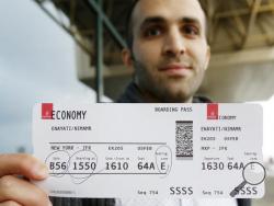 Iranian-born bioengineer researcher Nima Enayati holds up his boarding pass at the Milan's Malpensa International airport in Busto Arsizio, Italy, Sunday, Feb. 5, 2017. Just hours after an appeals court blocked an attempt to re-impose the travel ban, Iranian researcher Nima Enayati checked in on an Emirates Airline flight direct from Milan’s Malpensa airport to New York’s JFK on Sunday afternoon. (AP Photo/Antonio Calanni)