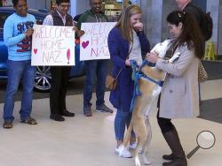 Nazanin Zinouri, 29, is greeted at the Greenville-Spartanburg International Airport in Greer, S.C., with kisses from her dog Dexter and well-wishers holding signs reading "Welcome Home" on Monday, Feb. 6, 2017. Zinouri, an Iranian engineer and Clemson University graduate, had been unable to return to the United States because of the executive order President Donald Trump signed that limited travel to the U.S. from seven Muslim-majority countries. (AP Photo/Alex Sanz)