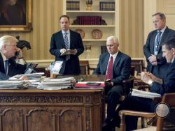 FILE - In this Jan. 28, 2017 file photo, President Donald Trump accompanied by, from second from left, Chief of Staff Reince Priebus, Vice President Mike Pence, White House press secretary Sean Spicer and then-National Security Adviser Michael Flynn speaks on the phone with Russian President Vladimir Putin, in the Oval Office at the White House in Washington. Trump's White House is nearly paralyzed by crisis, divisions and dysfunction. Virtually all policy announcements have slowed to a crawl. Aides are und