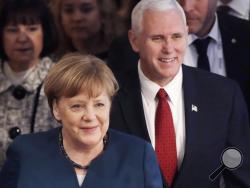 German Chancellor Angela Merkel, left, and United States Vice President Mike Pence arrive at the Munich Security Conference in Munich, Germany, Saturday, Feb. 18, 2017. The annual weekend gathering is known for providing an open and informal platform to meet in close quarters. (AP Photo/Matthias Schrader)