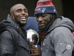 FILE - In this Feb. 7, 2017, file photo, New England Patriots safety Devin McCourty, left, and running back LeGarrette Blount hold a Super Bowl trophy during a rally in Boston to celebrate their win over the Atlanta Falcons in the NFL Super Bowl 51 football game in Houston. McCourty and Blount are among a half-dozen players that have turned down an expected invitation to the White House. (AP Photo/Elise Amendola, File)