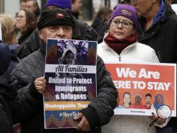 Wilfredo Mendoza, of Boston, left, and Christina Villafranca, of Malden, Mass., right, displays a placards during a rally called "We Will Persist," Tuesday, Feb. 21, 2017, in Boston. According to organizers the rally was held to send a message to Republicans in Congress and the administration of President Donald Trump that they will continue to press for immigration rights and continued affordable healthcare coverage. (AP Photo/Steven Senne)
