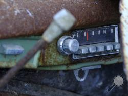 The push button radio still tuned to an 800 frequency on the AM dial on a Jeep Wagoneer that was salvaged Friday, Feb. 24, 2017, in Truro, Mass. Work crews early Friday pulled out the rusted remnants of what John Munsnuff says was once his family’s “beach buggy” at the home they’ve long owned near Ballston Beach in Cape Cod. (Steve Heaslip/The Cape Cod Times via AP)