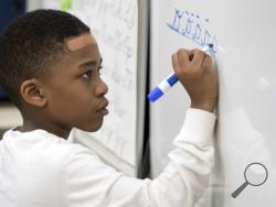 In this Wednesday, March 1, 2017, photo, a third-grader practices his cursive handwriting at P.S. 166 in the Queens borough of New York. Cursive writing is looping back into style in schools. Last fall, the 1.1 million-student New York City schools encouraged the teaching of cursive to students as young as the third grade. (AP Photo/Mary Altaffer)