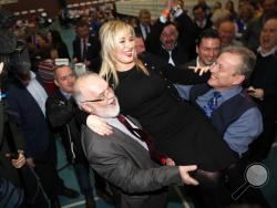 Sinn Fein's party leader for Northern Ireland Michelle O'Neill celebrates with party members Francie Molloy, left, and Ian Milne, right, after toping the poll in Mid Ulster, Ballymena count centre, Northern Ireland, Friday, March 3, 2017. Counting has begun across Northern Ireland with Irish Nationalists seeking to boost their vote in an early election that could shape the fate of the Catholic-Protestant cooperation in Northern Ireland. (AP Photo/Peter Morrison)