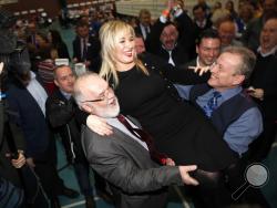 Sinn Fein's party leader for Northern Ireland Michelle O'Neill celebrates with party members Francie Molloy, left, and Ian Milne, right, after toping the poll in Mid Ulster, Ballymena count centre, Northern Ireland, Friday, March 3, 2017. Counting has begun across Northern Ireland with Irish Nationalists seeking to boost their vote in an early election that could shape the fate of the Catholic-Protestant cooperation in Northern Ireland. (AP Photo/Peter Morrison)