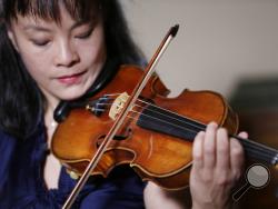 In this Wednesday, March 8, 2017 photo, violinist Mira Wang plays the Ames Stradivarius violin in New York. After a meticulous restoration that took more than a year, the Stradivarius violin that was stolen from violinist Roman Totenberg is about to return to the stage. Wang, a former student of Totenberg’s, will play the instrument at a private concert in New York on March 13. (AP Photo/Seth Wenig)