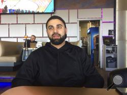 In this photo taken March 16, 2017, Hussein Dabajeh, 30, a lifelong Dearborn, Mich. resident who owns a hookah shop and lounge, said his ancestors first came to the U.S. from what’s now Lebanon in 1911. Still, he usually looks for the “other” box when offered the option on official forms and fully supports the idea of a new category for those who trace their roots to the Middle East. (AP Photo/Jeff Karoub)