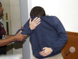 A 19-year-old dual U.S.-Israeli citizen covers his face as he is brought to court in Rishon Lezion, Israel, Thursday, March 23, 2017. Israeli police said they have arrested a Jewish Israeli man who is the prime suspect behind a wave of bomb threats against Jewish community centers and other institutions in the United States. The police withheld his identity. (AP Photo/Nir Keidar) 