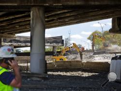 Construction crews work on a section of an overpass that collapsed from a large fire on Interstate 85 in Atlanta, Friday, March 31, 2017. Atlanta's dreadful rush-hour traffic got even worse Friday, the morning after a raging fire underneath Interstate 85 collapsed an elevated portion of the highway and shut down the heavily traveled route through the heart of the city. (AP Photo/David Goldman)