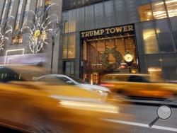FILE - In this Nov. 29, 2016, file photo, morning traffic on Fifth Avenue passes Trump Tower, in New York. For decades, President Donald Trump’s identity was interwoven with his hometown of New York City: big, brash and dedicated to making money. Manhattan was the imposing backdrop as Trump transformed himself from local real-estate developer to celebrity businessman, skyscrapers and gossip pages featured his name, and during last year’s presidential campaign he’d fly thousands of miles to sleep in his own 