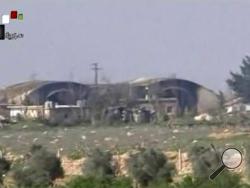 FILE - This file frame grab from video provided on Friday April, 7, 2017 by the Syrian official TV, a Syrian government channel that is consistent with independent AP reporting, shows the burned and damaged hangar warplanes which attacked by U.S. Tomahawk missiles, at the Shayrat Syrian government forces airbase, southeast of Homs, Syria. A U.S. missile attack on Friday, April 7, 2017 has caused heavy damage to one of Syria's biggest and most strategic air bases, used to launch warplanes to strike oppositio