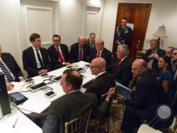 In this image provided by the White House, President Donald Trump receives a briefing on the Syria military strike from his National Security team, including a video teleconference with Secretary of Defense, Gen. James Mattis, and Chairman of the Joint Chiefs of Staff, Gen. Joseph Dunford, on Thursday, April 6, 2017, in a secured location at Mar-a-Lago in Palm Beach, Fla. (Shealah Craighead/The White House via AP)