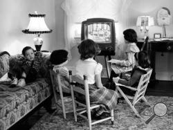 FILE - In this Jan. 6, 1953, file photo, four children watch a television in Baltimore, Md. Ever since freckle-faced puppet Howdy Doody ushered in children’s television nearly 70 years ago, each new generation of viewers has been treated to a growing bounty of programs on a mushrooming selection of gadgetry. Even so, it may be surprising that youngsters watch most television on a television. Just as their elders mostly still do, and always did, since TV first began. (AP Photo, File)