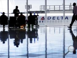 FILE - In this Thursday, Oct. 13, 2016, file photo, a Delta Air Lines jet sits at a gate at Hartsfield-Jackson Atlanta International Airport, in Atlanta. Delta is giving airport employees permission to offer passengers up to almost $10,000 in compensation to give up their seats on overbooked flights. Delta's move comes as United Airlines struggles to recover from images of a passenger's forced removal from a sold-out flight. (AP Photo/David Goldman, File)