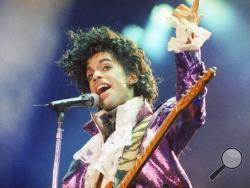  FILE - In this Feb. 18, 1985 file photo, Prince performs at the Forum in Inglewood, Calif. A year after Prince died of an accidental drug overdose, his Paisley Park studio complex and home is now a museum and concert venue. Fans can now stream most of his classic albums, and a remastered "Purple Rain" album is due out in June 2017 along with two albums of unreleased music and two concert films from his vault. (AP Photo/Liu Heung Shing, File)