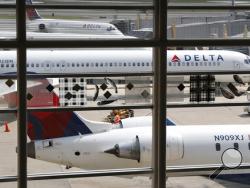FILE - In this Monday, Aug. 8, 2016, file photo, Delta Air Lines planes are parked at Ronald Reagan Washington National Airport, in Washington. A California family says they were forced off a Delta plane and threatened with jail after refusing to give up one of their children's seats on a crowded flight. A video of the April 23, 2017, incident was uploaded to Facebook on Wednesday, May 3, 2017, and adds to the list of recent encounters on airlines that went viral, including the dragging of a passenger off a