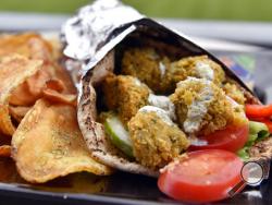 In this May 5, 2017, photo, a falafel sandwich from Harry the Ks Broadcast Bar and Grille at Citizens Bank Park is shown in Philadelphia. This sandwich includes house-made pita, lettuce, English cucumber, bell peppers, tomatoes and sesame mint yogurt sauce. (AP Photo/Derik Hamilton)