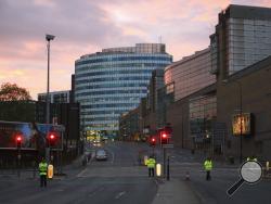  Police stand guard at dawn, after a blast at the Manchester Arena Tuesday, May 23, 2017. An explosion struck an Ariana Grande concert attended by thousands of young fans in northern England Monday night, killing more than a dozen of people and injuring dozens in what police were treating as a terrorist attack. (Peter Byrne/PA via AP)