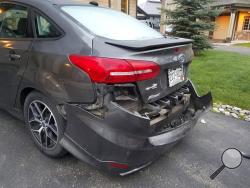 This Monday, May 22, 2017, photo shows a damaged delivery vehicle in Steamboat Springs, Colo. A bear damaged the bumper of the car used to deliver doughnuts in Colorado before it tried to claw its way through the trunk to get inside. (Kim Robertson via AP)