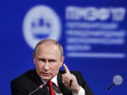  FILE - In this Friday, June 2, 2017, file photo, Russian President Vladimir Putin gestures as he speaks at the St. Petersburg International Economic Forum in St. Petersburg, Russia. Putin is dismissing as "a load of nonsense" the idea that Russia has damaging information on President Donald Trump and denies having any relationship with him, said Putin in an interview with NBC's "Sunday Night with Megyn Kelly." (AP Photo/Dmitry Lovetsky, File)