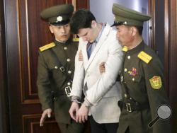  FILE - In this March 16, 2016, file photo, American student Otto Warmbier, center, is escorted at the Supreme Court in Pyongyang, North Korea. Warmbier, whose parents say has been in a coma while serving a 15-year prison term in North Korea, was released and returned to the United States Tuesday, June 13, 2017, as the Trump administration revealed a rare exchange with the reclusive country. (AP Photo/Jon Chol Jin, File)