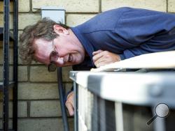  Alan Schwandt, an air conditioning repairman, examines a broken outdoor unit in Scottsdale, Ariz., Monday, June 19, 2017. Repairmen are constantly on call in the summer, as temperatures in the Phoenix metro area rise to nearly 120 degrees. (AP Photo/Angie Wang)