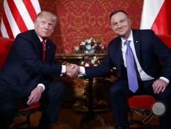  U.S. President Donald Trump, left, and Polish President Andrzej Duda pose for photographers as they shake hands during their meeting at the Royal Castle, Thursday, July 6, 2017, in Warsaw. (AP Photo/Evan Vucci)