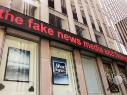 News headlines scroll above the Fox News studios in the News Corporation headquarters building in New York, Tuesday, Aug. 1, 2017. Fox contributor Rod Wheeler, who worked on the Seth Rich case, claims Fox News fabricated quotes implicating the murdered Democratic National Committee staffer in the Wikileaks scandal and that President Donald Trump pressured Fox to publish the story. He sued Fox for defamation on Tuesday. (AP Photo/Richard Drew)