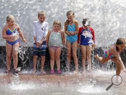 One child bolts as others hold their ground as water begins to spray out at the International Fountain at the Seattle Center during a heat wave Wednesday, Aug. 2, 2017, in Seattle. Forecasts for triple-digit heat have caused a minor panic across the Pacific Northwest, a region famous for cool weather that is getting blasted with a Phoenix-like furnace after a coastal weather pattern went into reverse. (AP Photo/Elaine Thompson)